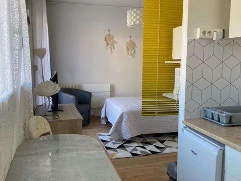 mały pokój z łóżkiem i żółtym oknem w obiekcie Studio Centre-Ville avec Terrasse, Équipé, Lumineux - FR-1-703-8 w mieście Amélie-les-Bains-Palalda