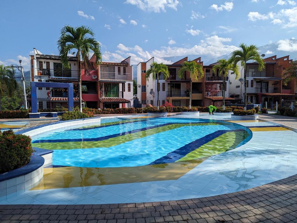 une grande piscine avec des palmiers et des bâtiments dans l'établissement Apartasol en San Jerónimo, Ciudadela del Sol - Cammar, à San Jerónimo