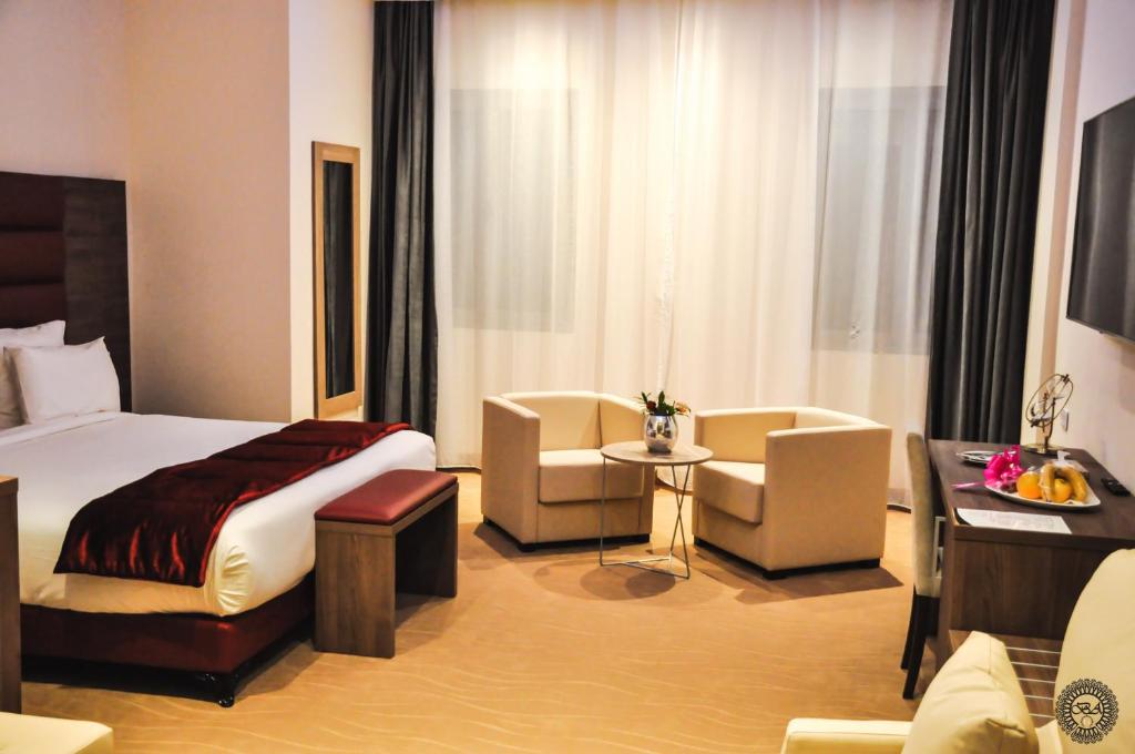 Habitación de hotel con cama, mesa y sillas en Hôtel des beaux-arts en Argel