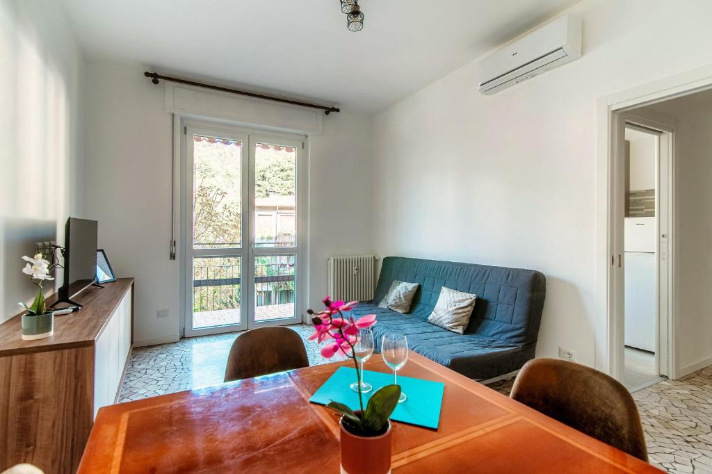 ein Wohnzimmer mit einem Tisch und einem blauen Sofa in der Unterkunft S.M. DOWNTOWN CERNOBBIO APARTMENT in Cernobbio
