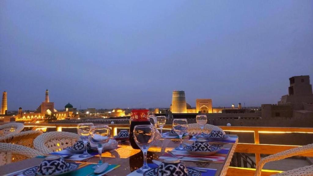 a table with wine glasses on top of a balcony at Art House Boutique Hotel in Khiva