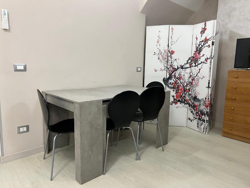 una mesa con 4 sillas en una habitación en L’angolo in piazza, en Biccari