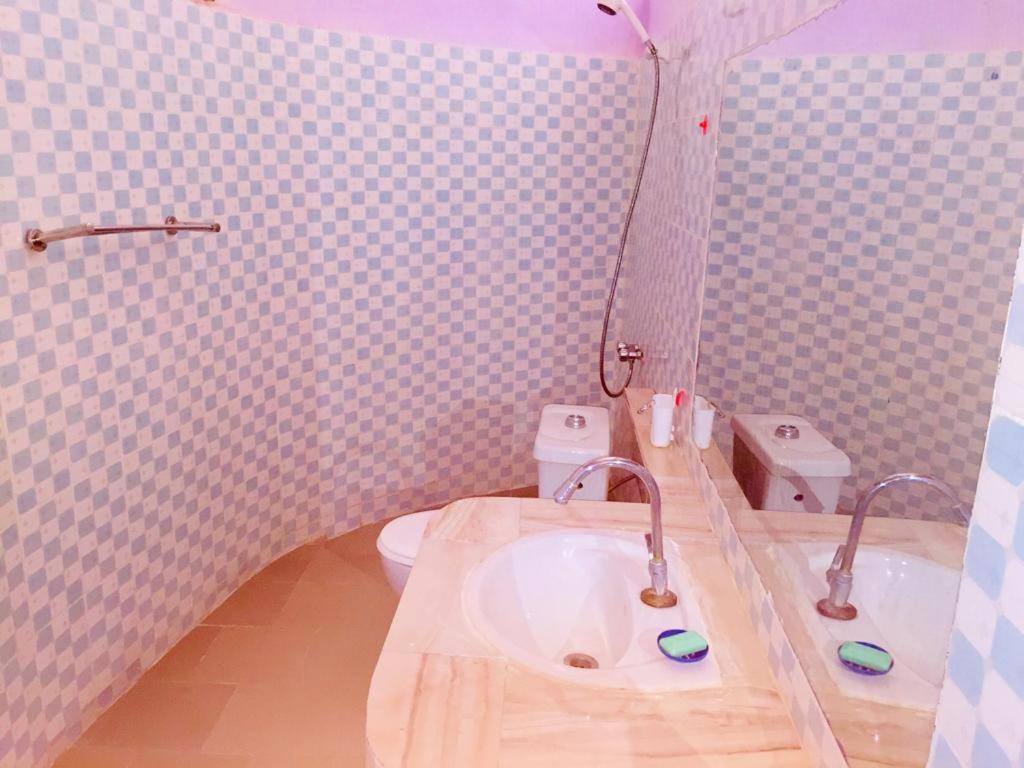 ein Bad mit einem Waschbecken und einem WC in der Unterkunft Hotel Toolbi in Niaga