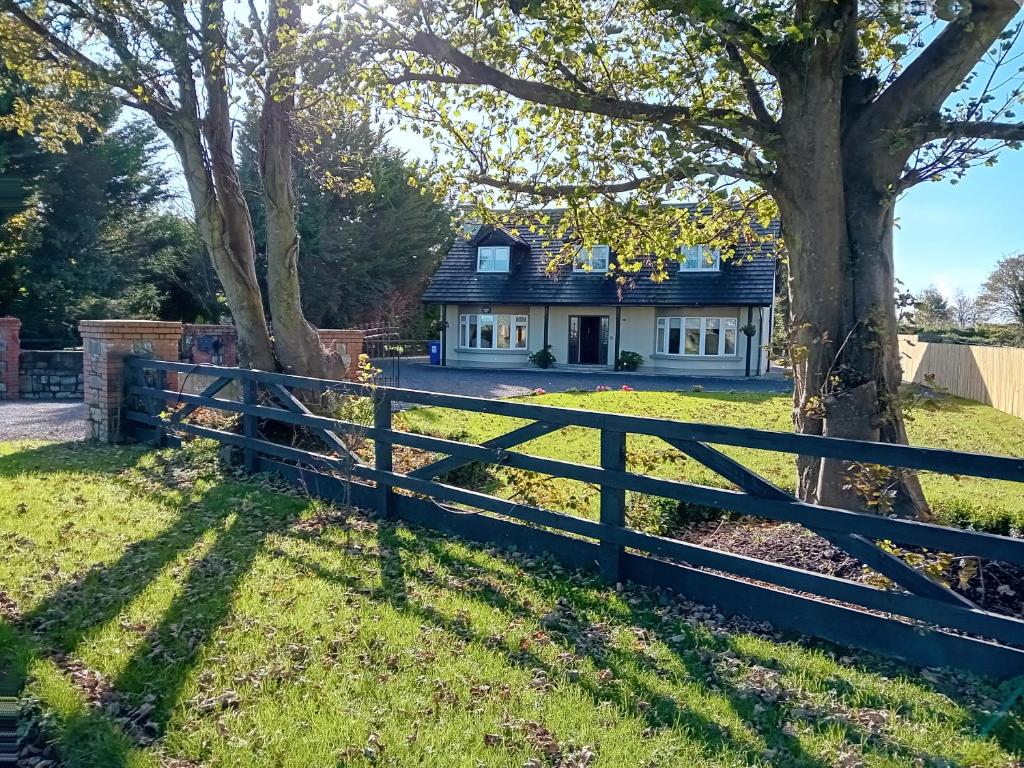 una casa con una valla y un árbol en White Quarry House, en Navan