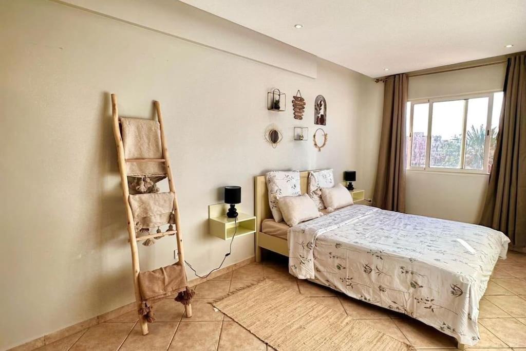 - une chambre avec un lit, une étagère et une fenêtre dans l'établissement Adorable 2-bedrooms flat in Gueliz, à Marrakech