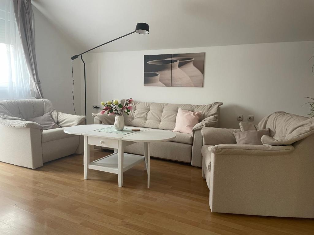 - un salon avec un canapé et une table dans l'établissement Apartman Magnolija, à Zemun