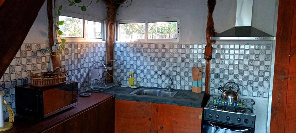 a kitchen with a sink and a stove at Los diablitos in Punta Del Diablo