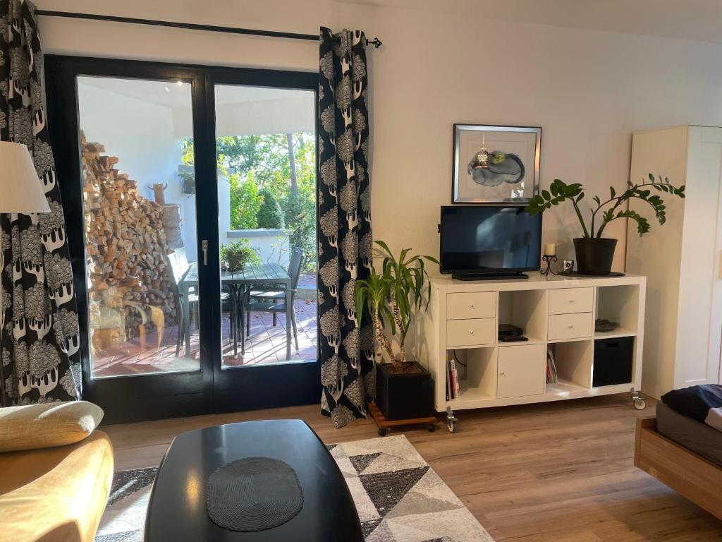 a living room with a tv and a sliding glass door at Apartment Frohnau in Berlin