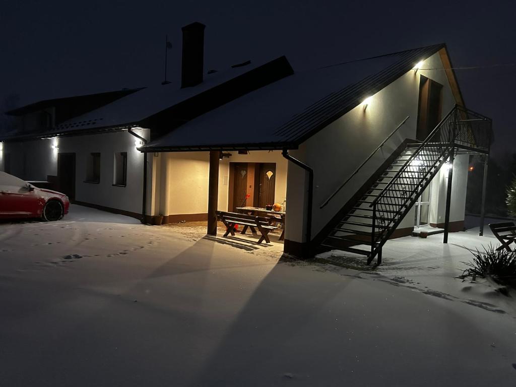 un bâtiment avec un escalier à côté d'une maison dans l'établissement Mendokowe Ranczo, à Górno-Parcele