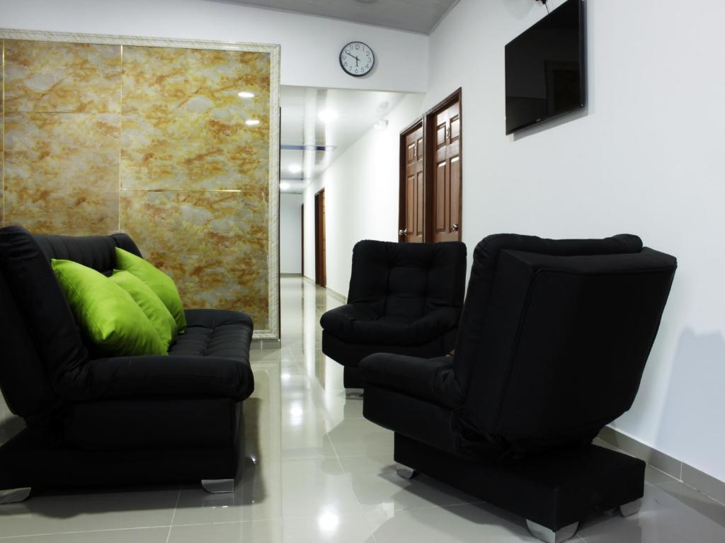 a living room with two chairs and a television at Hotel el Cable Centro de Pereira in Pereira