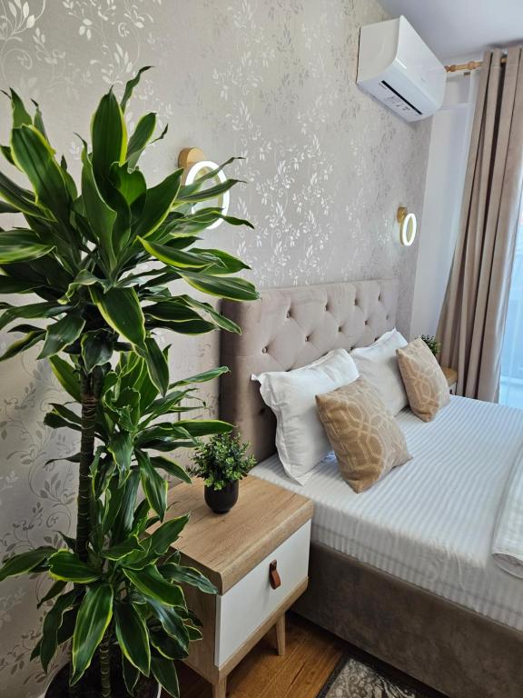 a bedroom with a bed and a potted plant at Luxury Apartment in Bucharest