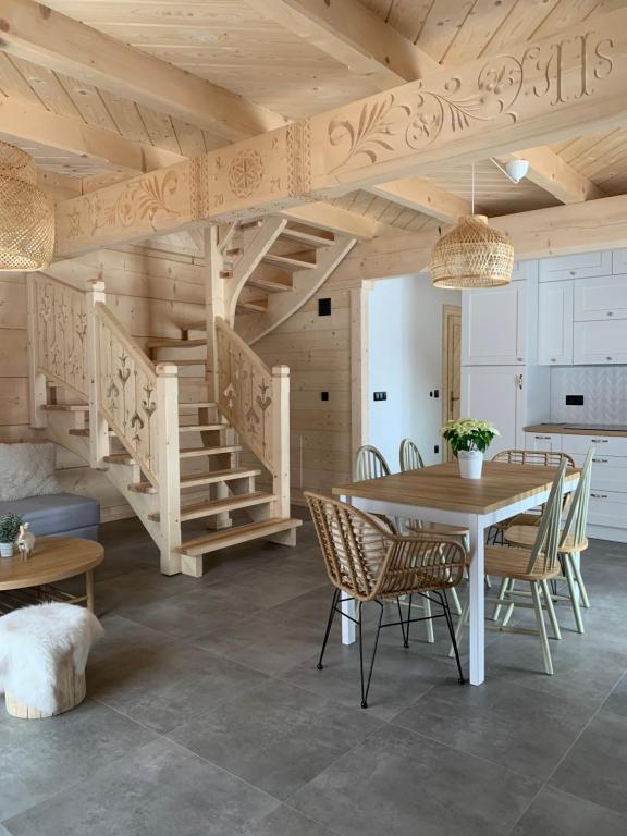 a dining room with a table and a wooden ceiling at Uroczy drewniany domek - Domki pod Brzegiem in Zakopane