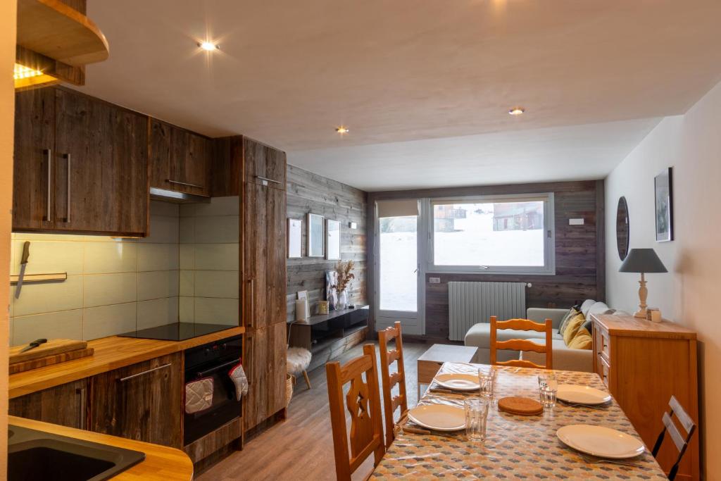 une cuisine et une salle à manger avec une table et des chaises dans l'établissement Tignes - Appartement vue golf, à Tignes