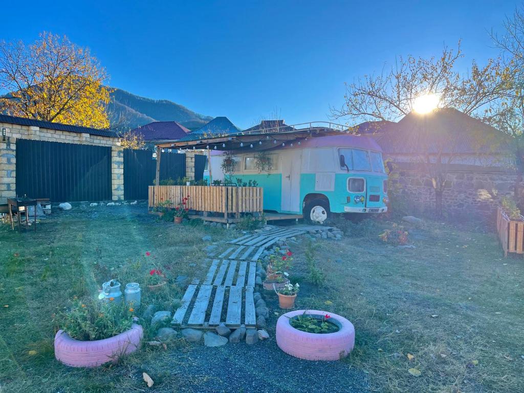 an rv parked in a yard with plants in a backyard at Pavlove Tiny Bus House in Qabala in Gabala
