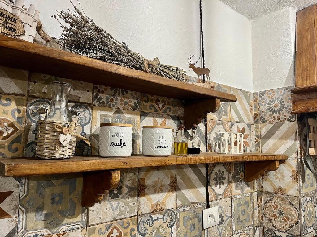 uma prateleira com três canecas em cima de uma parede de azulejos em Baita delle Rocche em Rocca di Mezzo
