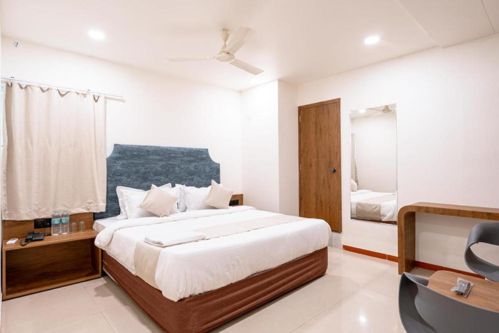 Schlafzimmer mit einem Bett, einem Schreibtisch und einem Stuhl in der Unterkunft hotel silver tree in Rajkot