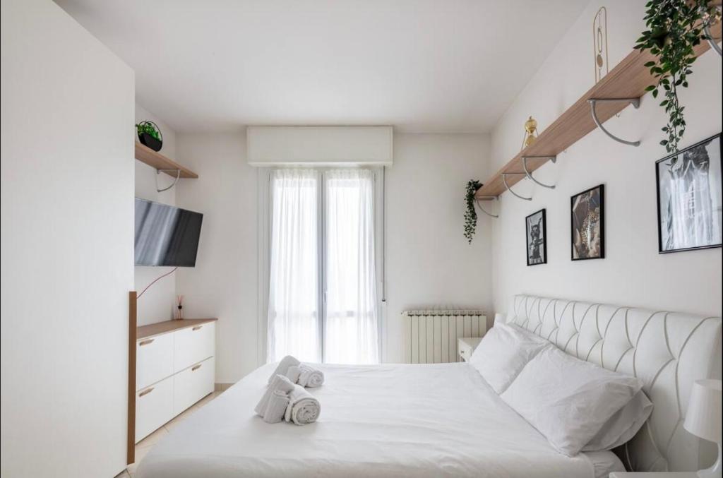 a white bedroom with a bed and a window at Formigine - [Motor Valley-Homes] in Formigine