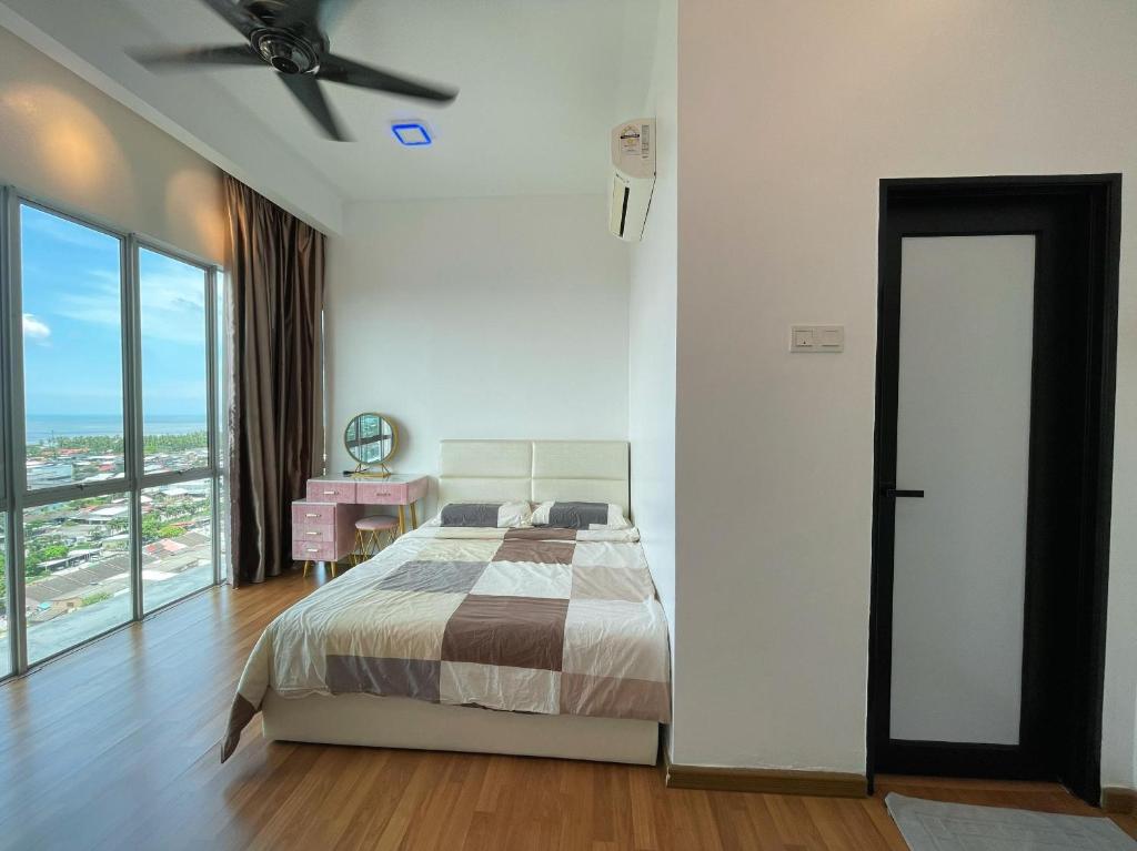 a bedroom with a bed and a ceiling fan at Sekinchan Simple LoveSea House ~ Seaview 3-14AB in Sekincan
