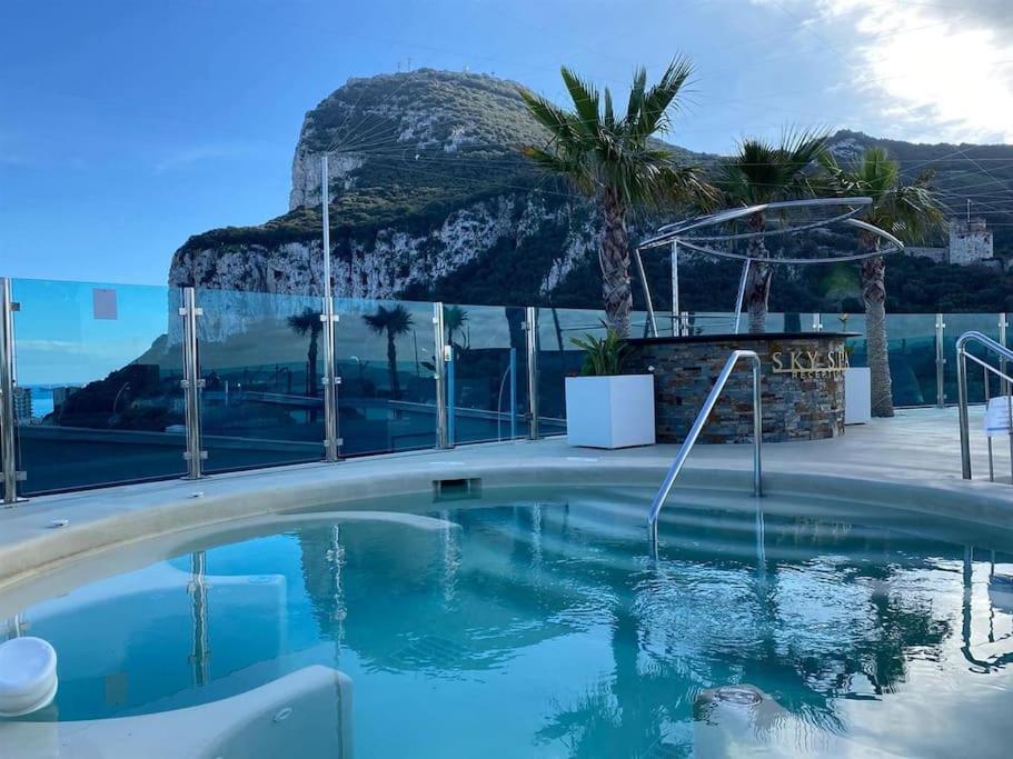 a swimming pool at a resort with a mountain in the background at Hidden Gem at Luxurious Ocean Village in Gibraltar