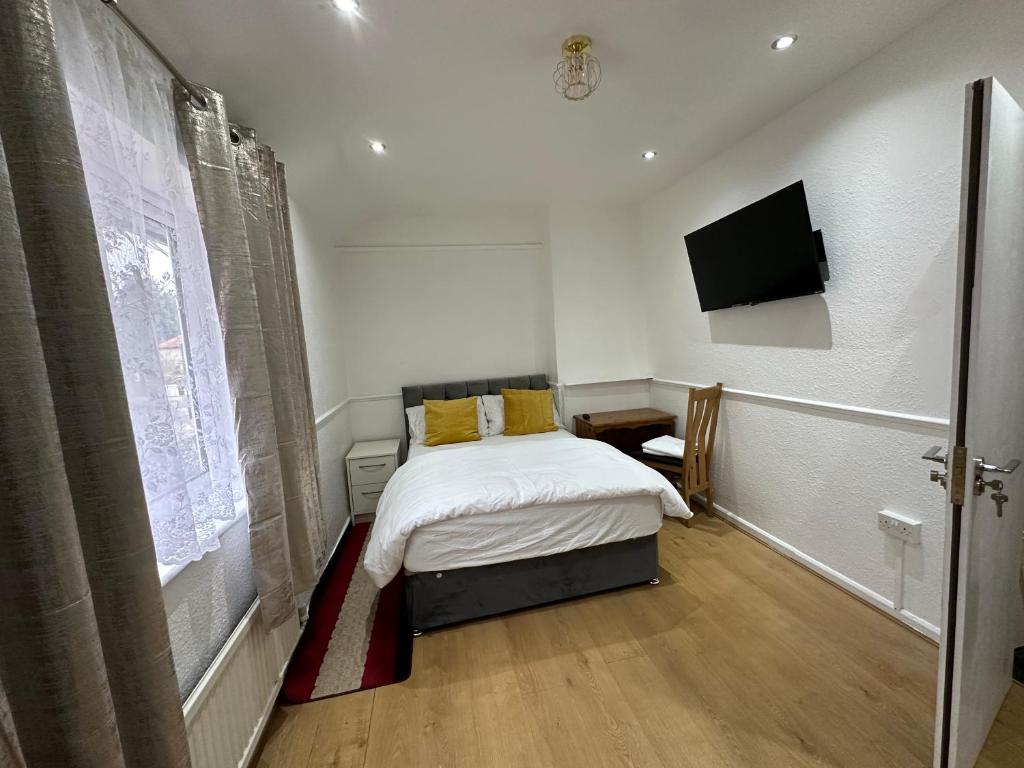 a bedroom with a bed and a flat screen tv at Double Room With Free WiFi Keedonwood Road in Bromley