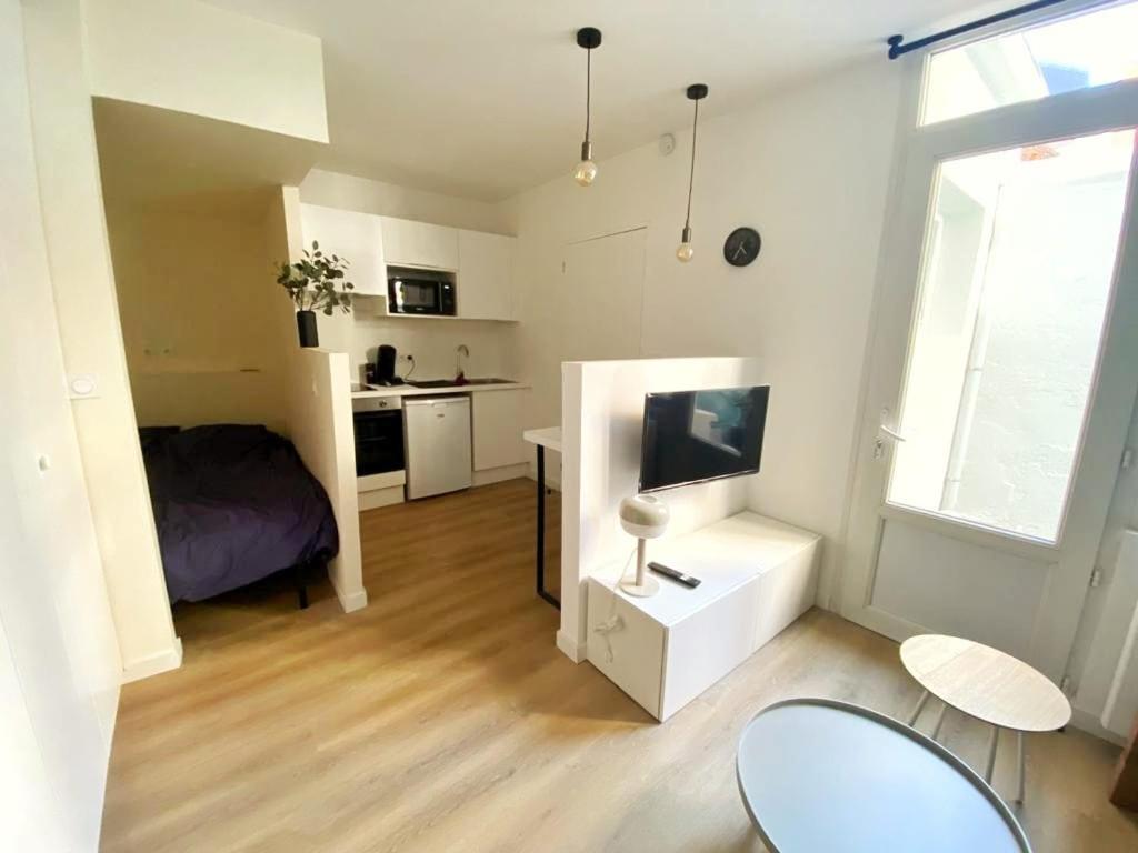 een kleine woonkamer met een bed en een televisie bij L'alcôve (Centre - Gare - Commerces) in Lens