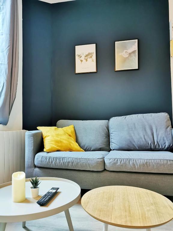 un salon avec un canapé bleu et une table dans l'établissement L'alcôve (Centre - Gare - Commerces), à Lens