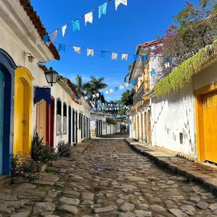 an alley with flags and buildings in a town at Casinha Centro histórico in Paraty