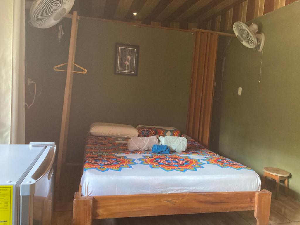 a small bed in a room with a fan at Pez Espada Tours y Cabinas in Drake