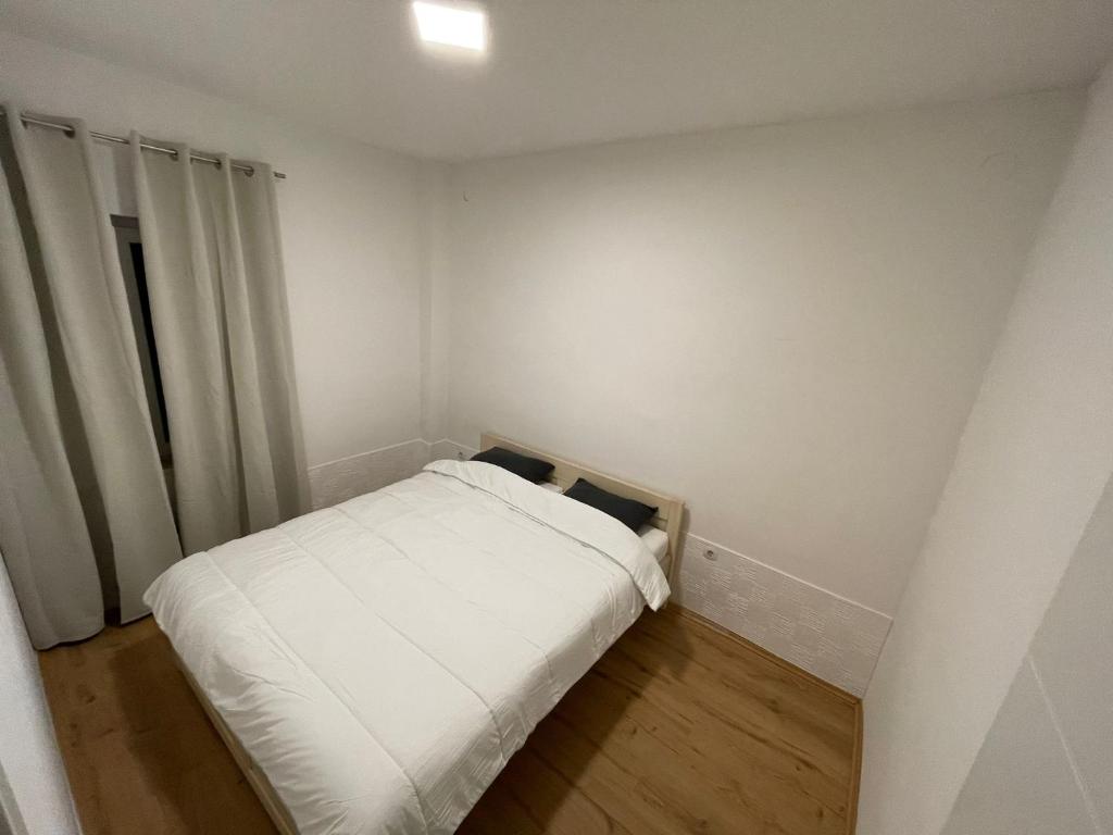 niewielka sypialnia z białym łóżkiem i oknem w obiekcie City Centre Rooms - self check in w Zagrzebiu