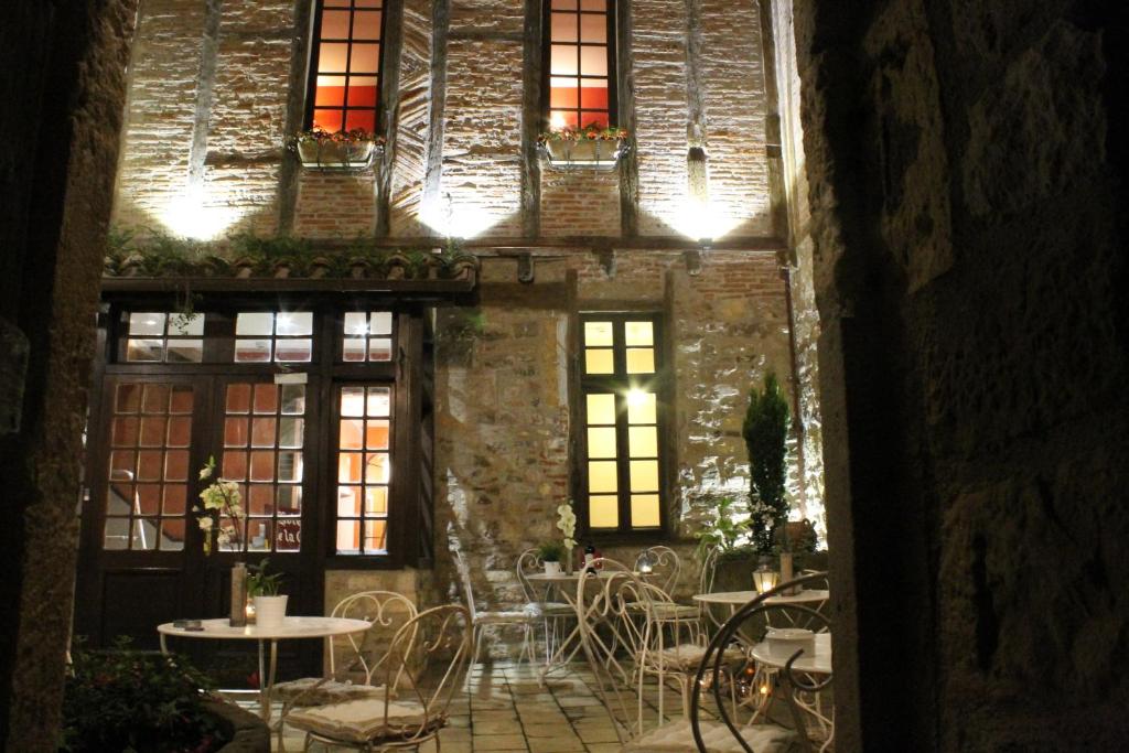 an entrance to a restaurant with tables and chairs at Hotel Raymond VII in Cordes-sur-Ciel