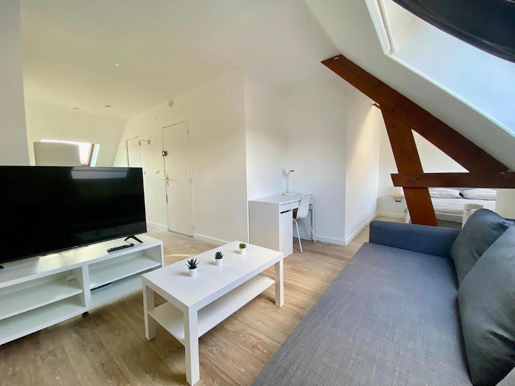 a living room with a couch and a flat screen tv at Welcome Home in Vert-le-Grand