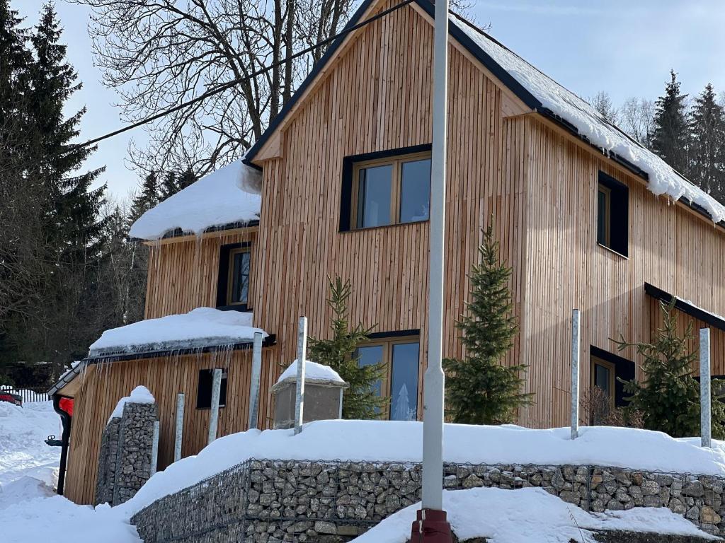 una casa de madera en la nieve con nieve en Chalette Jasan, en Josefŭv Dŭl