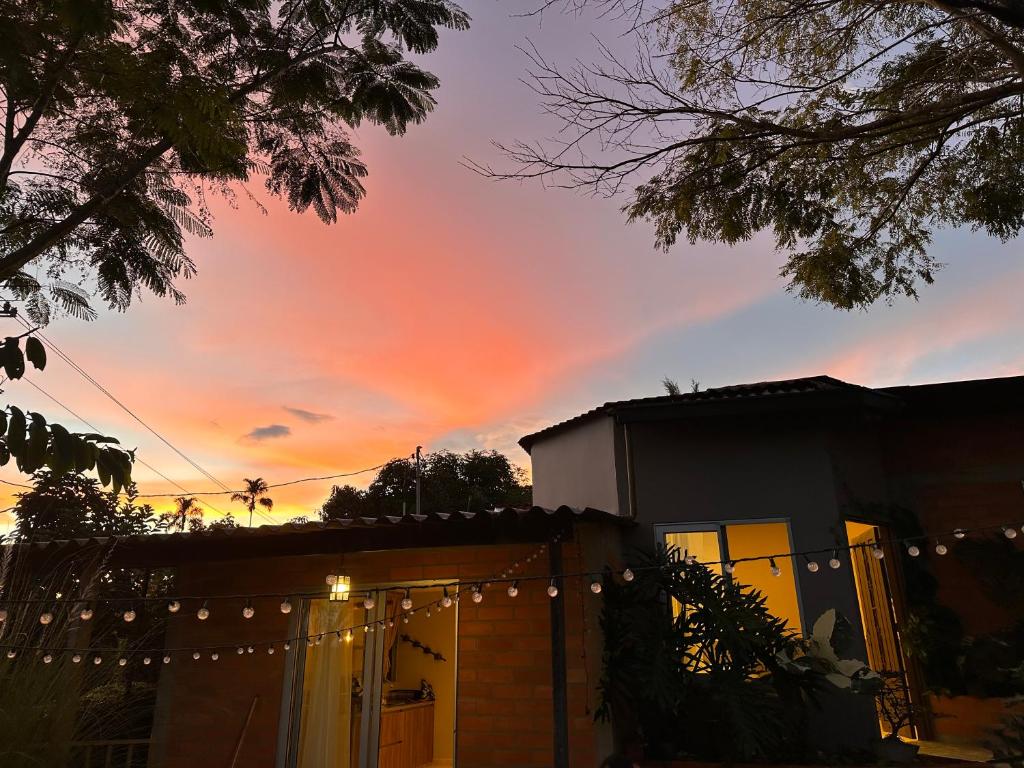 a rainbow in the sky over a house with a fence at Casa de Ali in Pereira