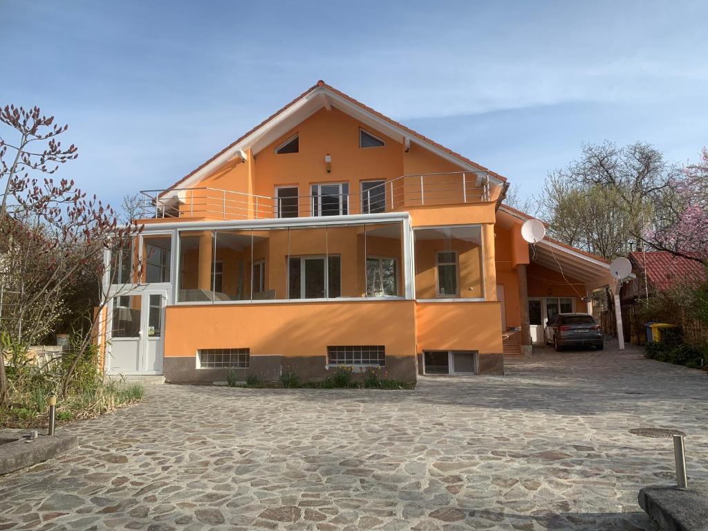 een groot oranje gebouw met een oprit ervoor bij Casa Portocalie in Cisnădie