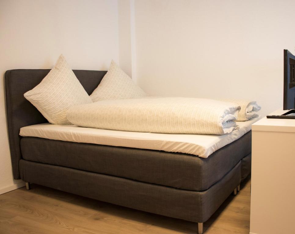 Bett mit Kissen darüber in einem Zimmer in der Unterkunft Modernes Apartment 3 in Bad Kreuznach mit einfachem Self-Check-in in Bad Kreuznach
