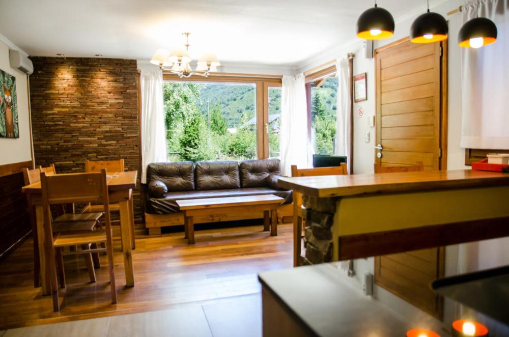 sala de estar con sofá y mesa en Apartamentos Catedral Inn en San Carlos de Bariloche