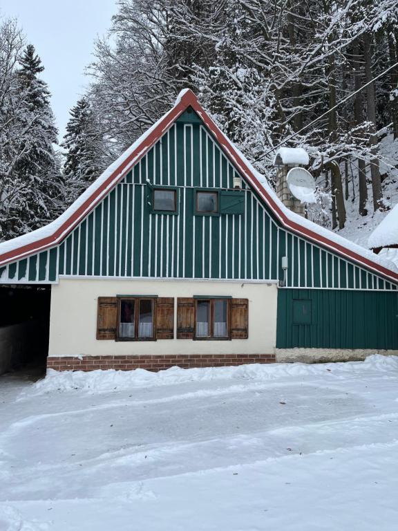 a green and white house in the snow at Chaloupka u Káji in Vítkovice