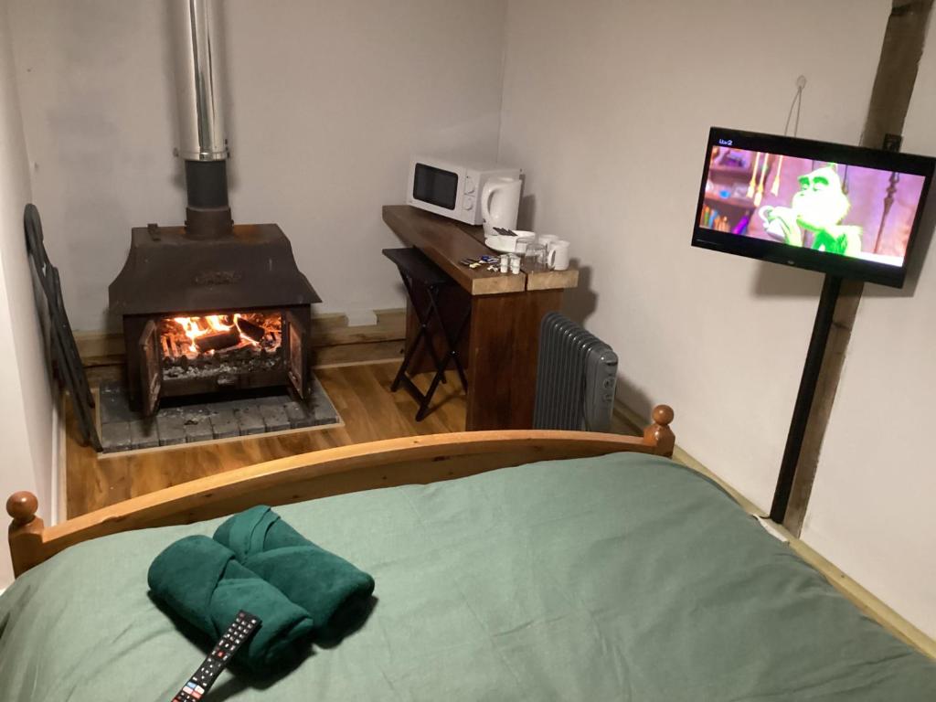 a room with a fireplace and a tv and a bed at Barn 6 in Vigo Village
