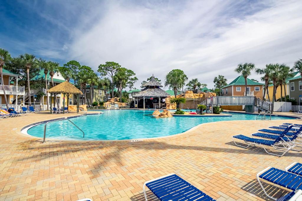 een zwembad in een resort met blauwe ligstoelen bij Perdido Sunrise 9b By Pkrm in Pensacola