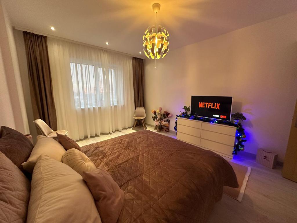una camera con un grande letto e una televisione di Cherry Apartment a Bucarest