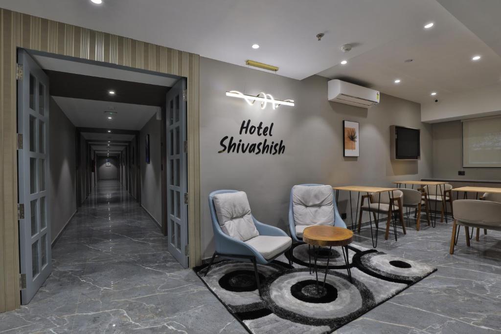 uma sala de espera com cadeiras e uma placa que lê shinkhub do hotel em Hotel Shivashish em Ahmedabad