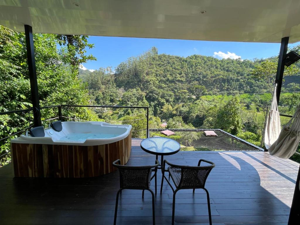 a tub on a deck with two chairs and a table at La ceiba cabaña in La Vega