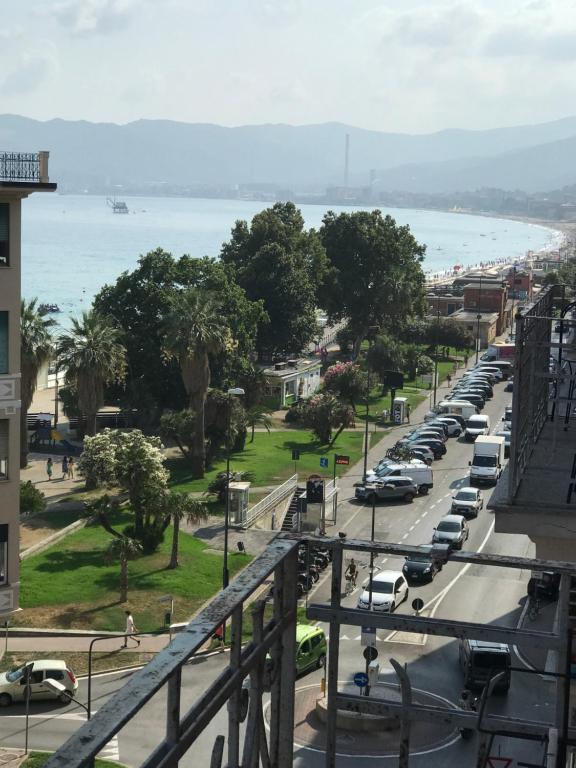 uma movimentada rua da cidade com carros estacionados na estrada em Appartamento davanti al mare em Savona