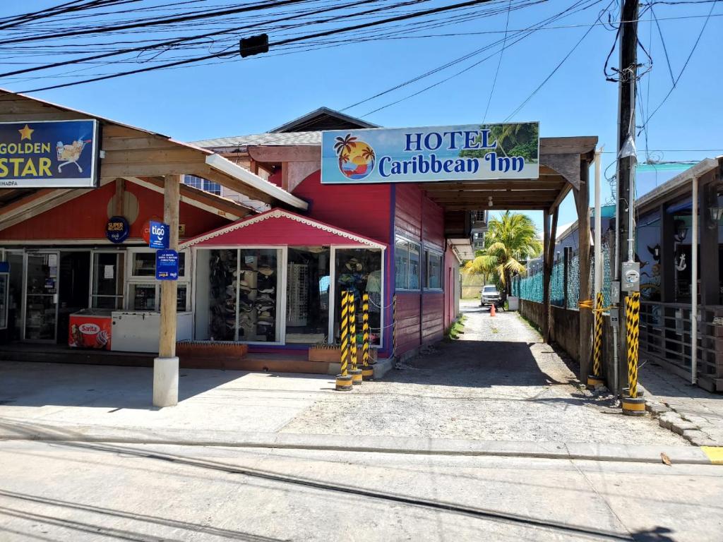 una calle vacía con un distintivo de giro caribbean de hotel en Hotel Caribbean Inn, en West End