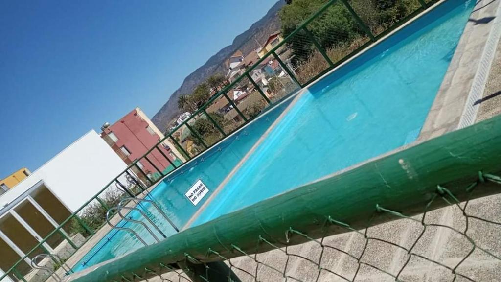 a swimming pool with a tennis racket and a fence at Departamento viña del mar in Viña del Mar