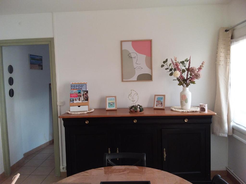 Cette chambre dispose d'un bureau avec un vase de fleurs. dans l'établissement Le Dalton, à Boulogne-sur-Mer