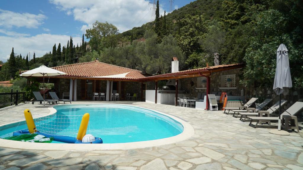 una piscina con sillas y una casa en Skaloma Beach Estate, en Skaloma