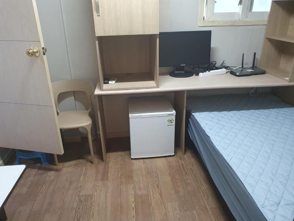 a room with a desk and a bed and a desk with a computer at Halla Livingtel in Goyang