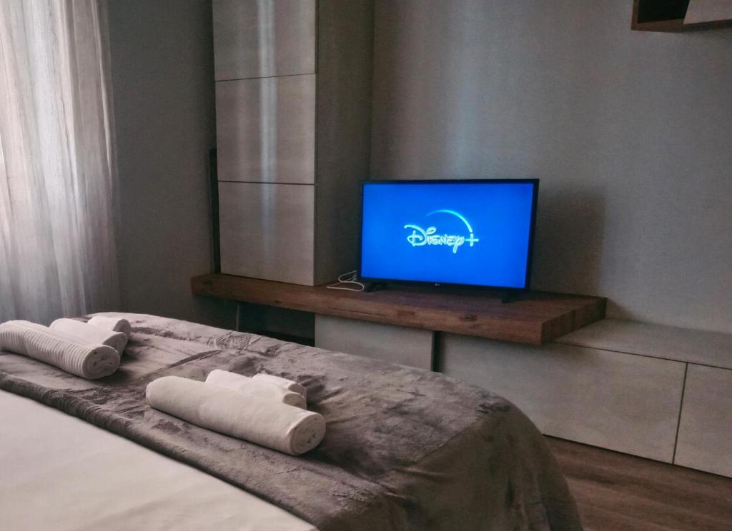 1 dormitorio con 1 cama con 2 toallas enrolladas y TV en Graziosa casetta vicino alla Metro, en Roma