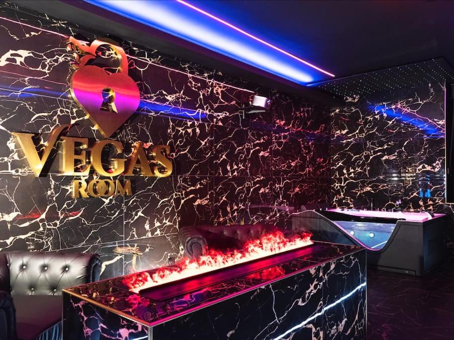 einen Nachtclub mit einer roten Marmorwand mit einem Schild in der Unterkunft Vegas Room - Luxury in Serémange-Erzange